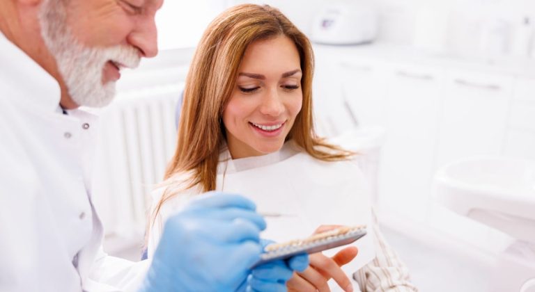 Dentist showing to patient zirconium dental veneers color palette