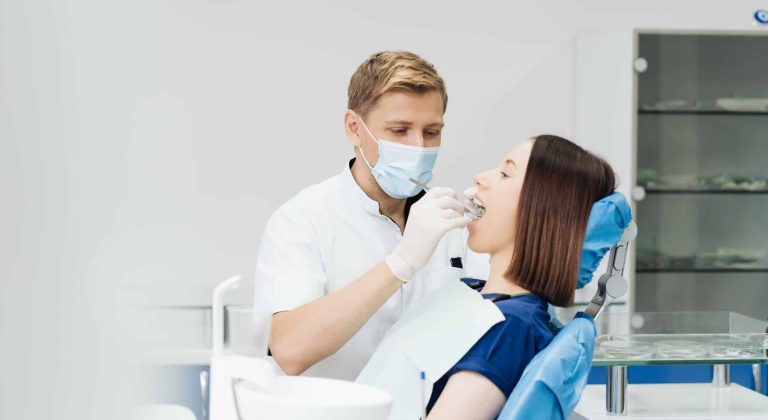 Dentist check patient cavity using instruments at clinic